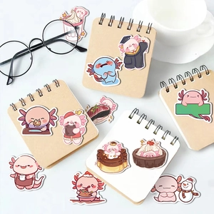 Cute axolotl stickers on a notebook with glasses and coffee cup on a bright desk