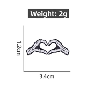 Vue détaillée du pin's main de squelette en cœur avec dimensions 3,4cm et poids de 2g