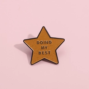 Retro star-shaped enamel brooch in orange with Doing My Best lettering and glitter detail