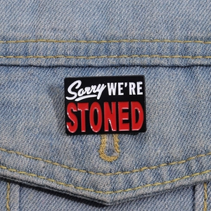 Creative enamel brooch with Sorry We Are Stoned text on blue denim jacket pocket