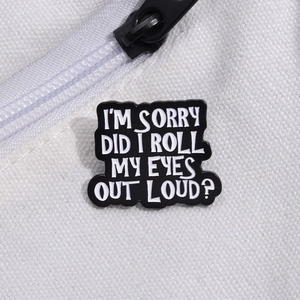 Black enamel pin with funny white text on white canvas backpack background