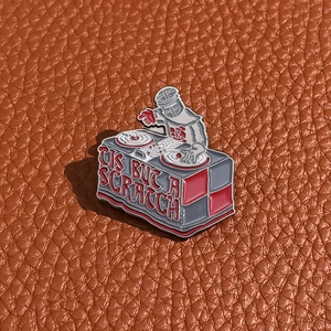 Macro shot of Black Knight on DJ deck enamel pin with 'TIS BUT A SCRATCH' text