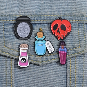 Detail of five whimsical enamel pins featuring magic potions on a blue denim jacket