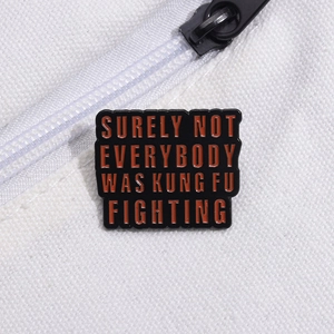 Enamel pin with Kung Fu Fighting text attached to a white canvas backpack pocket
