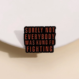 Black square enamel pin with 'Surely Not Everybody Was Kung Fu Fighting' red text