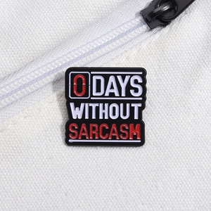 Funny black enamel pin with 0 DAYS WITHOUT SARCASM text on white canvas background