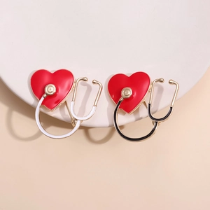 Creative stethoscope heart enamel pins in red and white colors for medical professionals