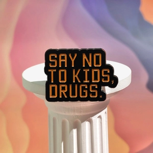 Black enamel pin with slogan Say No To Kids Drugs on minimalist display stand
