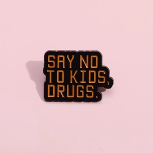Black enamel metal pin badge with orange Say No To Kids Drugs quote for teenagers