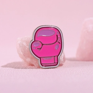 Detalle de broche de esmalte de guante de boxeo rosa sobre piedras de cristal rosa