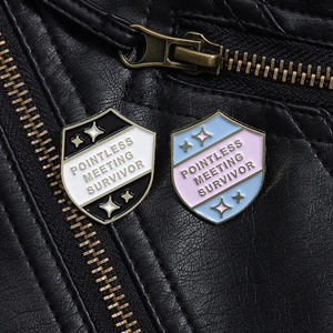 Close-up of Pointless Meeting Survivor enamel pin on a black leather jacket
