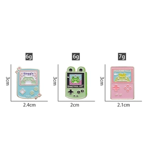 Detail view showing dimensions and weight of retro frog game console enamel pins