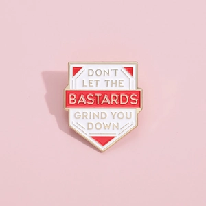 Shield enamel pin featuring red and white panels with English quote on pink background
