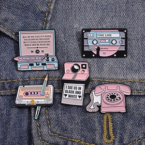 Five-piece set of retro pink enamel pins featuring vintage music players on denim