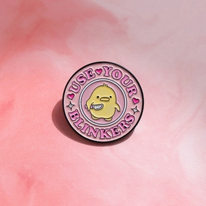 Cartoon yellow duck enamel pin with pink background and USE YOUR BLINKERS text