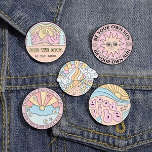 Five-piece pastel enamel pin set with sun and rainbow themes on a blue denim jacket