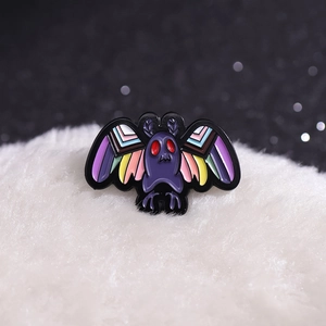 Dark punk moth enamel pin with red eyes and multicolored wings on white fur