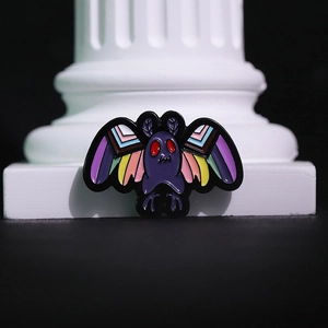 Gothic dark punk mothman enamel pin with red eyes and colorful wings on a classic pillar