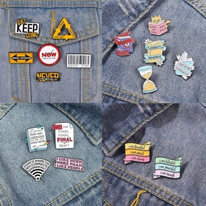 Collection of motivational enamel pins and slogan brooches on denim jacket