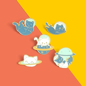 Detailed set of five cartoon enamel space cat pins with gold edges on yellow background