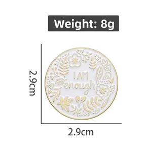 Detail view of round 'I AM enough' enamel brooch with floral pattern and 2.9cm dimension