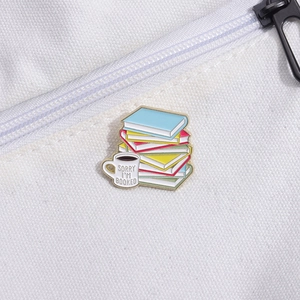 Detail of enamel pin with colorful books and coffee cup on white canvas bag