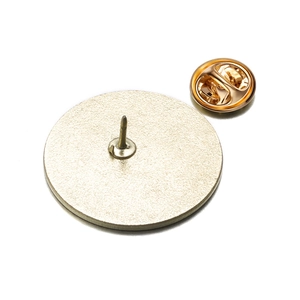 Close-up of the golden metal pin back and butterfly clutch on a round geometric badge