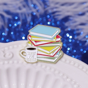 Creative coffee and book enamel pin with 'Sorry I'm Booked' text on a stylish tray