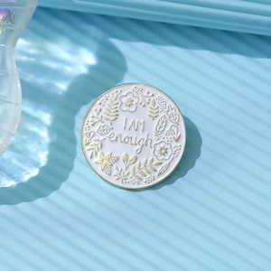Minimalist round floral enamel pin badge featuring I AM enough text on striped background