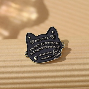 Gothic black enamel cat brooch with gold Meowja Ouija board letters and stars