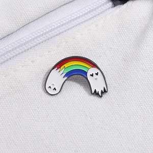 Close-up of cute white ghost enamel pin with rainbow stripes on white canvas bag