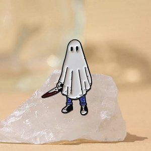 Broche émaillée fantôme d'Halloween avec un poignard ensanglanté sur une pierre