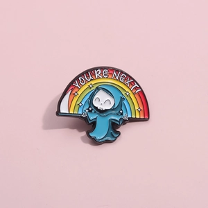 Cute grim reaper enamel pin with rainbow and 'YOU'RE NEXT!' text on pink background