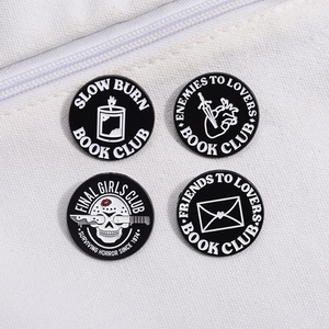 Set of four black enamel pins with horror and bookish themes like Slow Burn and Final Girl