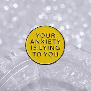 Pin de santé mentale jaune avec la phrase Your Anxiety is Lying to You dans un cadre rond