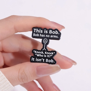 Black enamel brooch featuring a cartoon character and humorous text quote badge