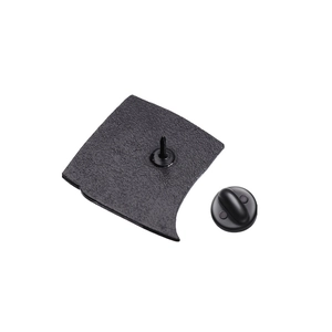 Macro view of geometric metal badge back showing textured surface and black rubber clutch