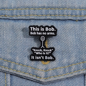 Detail of creative Bob enamel pin with stickman drawing on denim jacket pocket