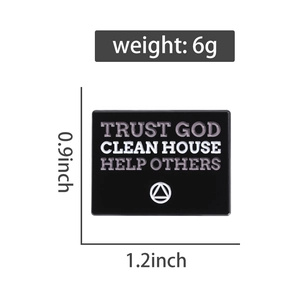 Detail shot of black enamel pin with Trust God quote and white triangle logo symbols