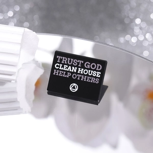 Macro shot of black enamel pin with text Trust God Clean House Help Others