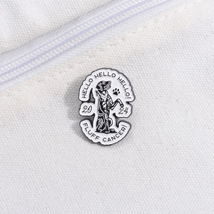 Détail d'un pin's rond en émail avec illustration de chien noir et blanc sur un sac en toile