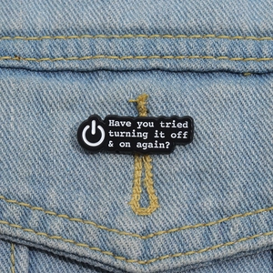 Badge en émail noir avec texte Have you tried turning it off sur une veste en denim