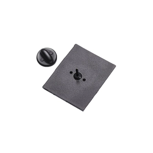 Close-up of black matte metal badge back with butterfly clutch pin fastener