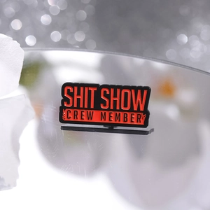 Funny Shit Show Crew Member enamel pin with red and black lettering on silver stand