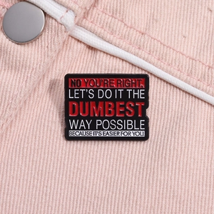Makro-Detail der Emaille-Brosche mit lustigem englischem Spruch auf rosa Jeansstoff