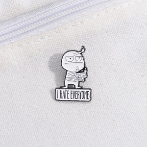 Close-up of a white cartoon character lapel pin with 'I HATE EVERYONE' text on canvas