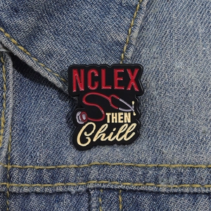 Détail macro du pin's émaillé NCLEX THEN Chill avec stéthoscope rouge sur denim