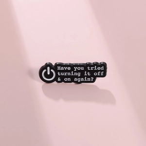 Broche en émail noir avec texte humoristique et icône d'alimentation sur fond rose