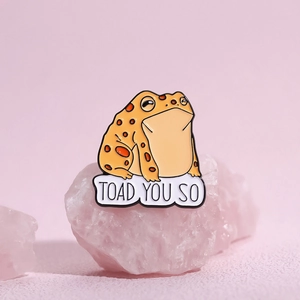 Cute orange cartoon toad enamel pin with Toad You So pun on a pink crystal background