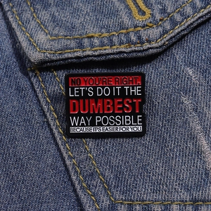 Nahaufnahme der Emaille-Brosche auf Denim mit humorvollem englischem Textzitat